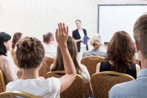 Listener raising hand to ask a question.