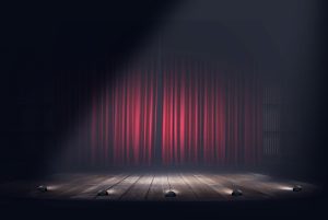 An empty stage with red velvet curtains