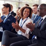 Smiling audience applauding at a business seminar