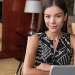 Confident writer at laptop looking directly at camer