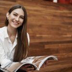 Business woman holding a magazine, smiling