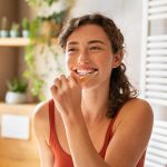 Smiling woman brushing her teeth