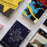 Classic books on a table, including The Catcher in the Rye and The Grapes of Wrath