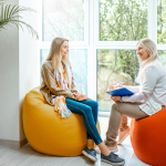 Two women network, sitting on comfortable chairs in a sunny space