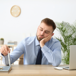 bored male writer sits at desk with no clients