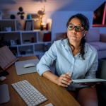 woman working late at her computer, needs to ask for a deadline extension