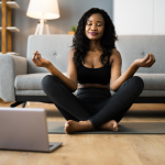 Women doing yoga with laptop in front of her