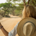 Woman on a desert road sticks out her thumb for a ride