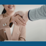 A smiling woman shakes hands with a new client
