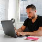 man intently looks into his computer
