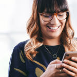Smiling young professional woman texts her favorite client