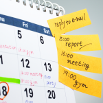 Paper wall calendar flagged with appointment reminders