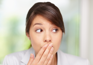 woman puts her hand over her mouth as an oops gesture