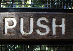 push sign on a screen door